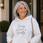 Woman wearing a white hoodie with 'Every Woman is Worthy' text, standing outdoors.
