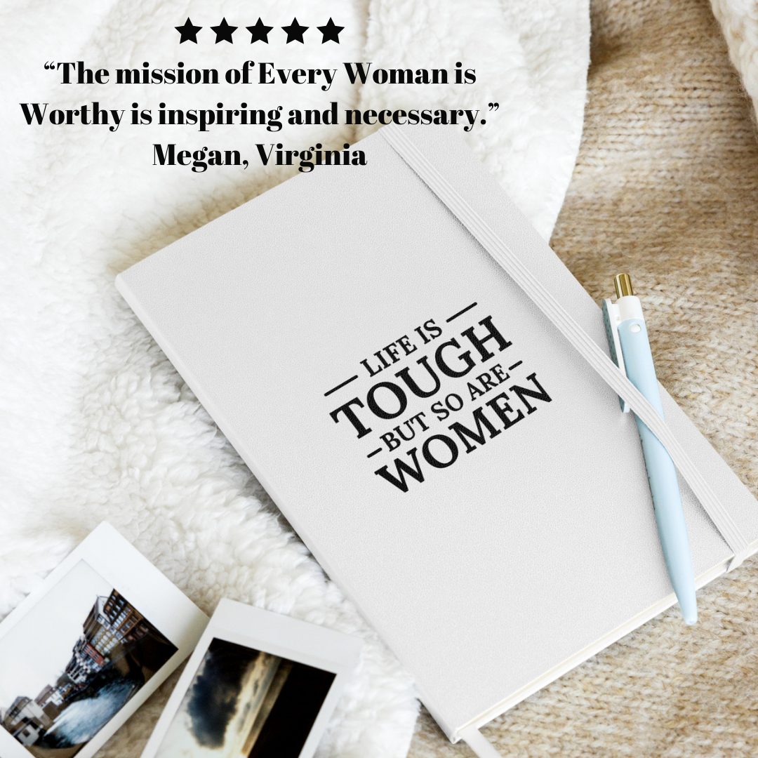 Notebook with motivational quote on a textured surface with photos and a pen.